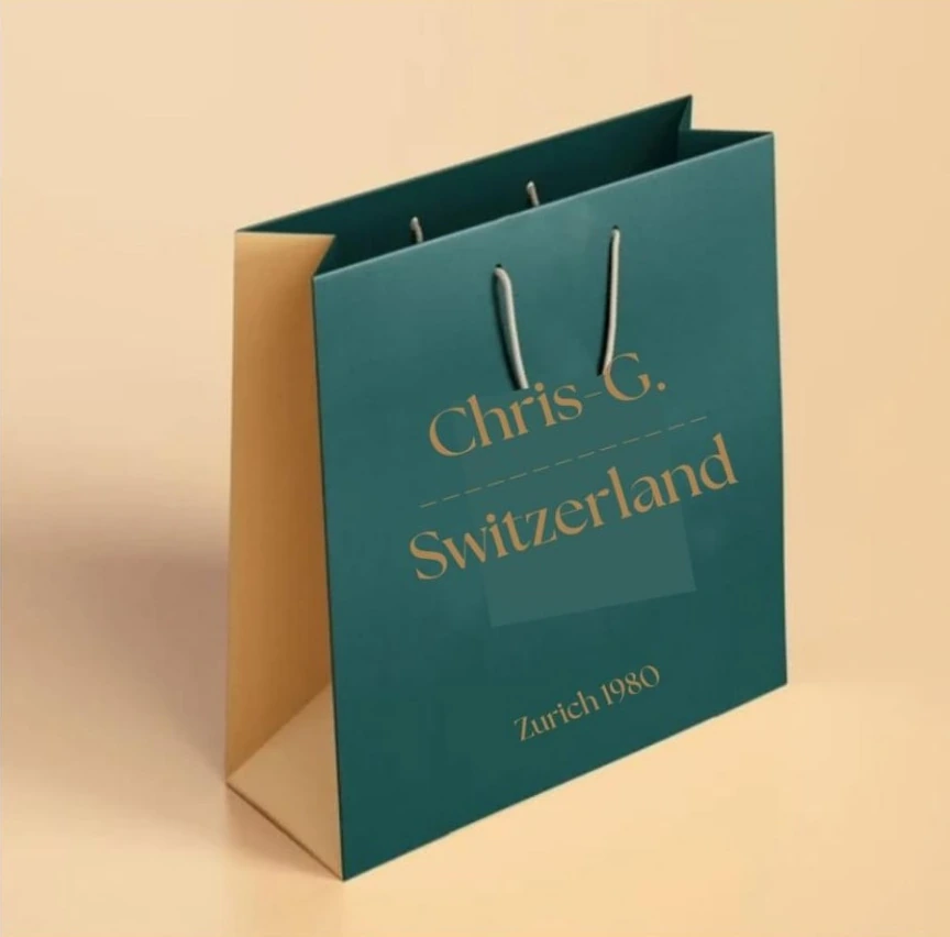Grün-goldene Chris-G.-Tragetasche mit Logo und Kordelgriffen