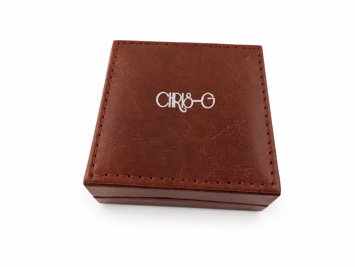 Quadratische braune Chris-G.-Schmuckbox mit sichtbarer Oberflächenstruktur und Naht